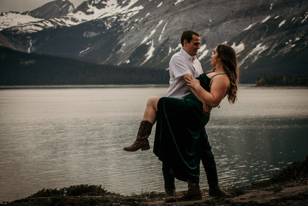 A sweet and romantic engagement photo of the man dipping his partner with Canadian Rockies in the backdrop