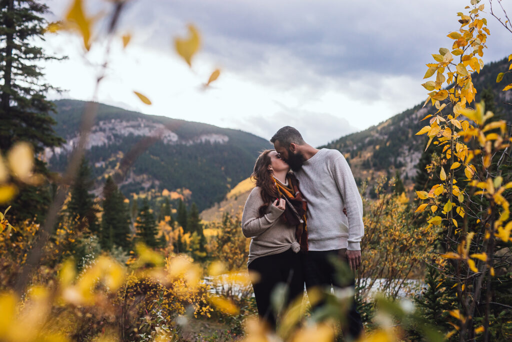 A romantic engagement photo in Alberta with mountains in the backdrop