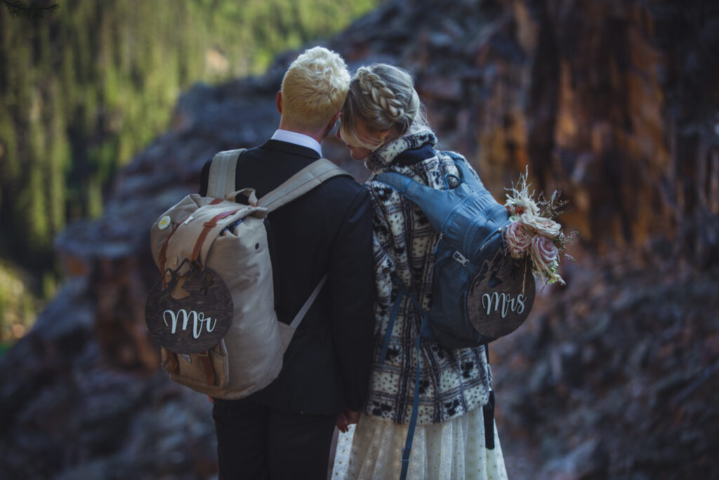 romantic bride and groom hiking elopement photo with backpacks
