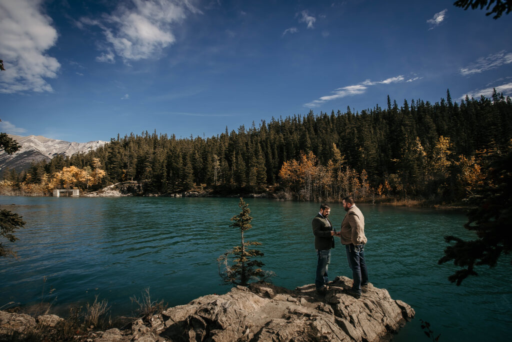 Couple eloping at Abraham Lake with the fall colors, known for frozen ice bubbles and snowy mountain scenery, but also stunning turquoise water and towering evergreens.