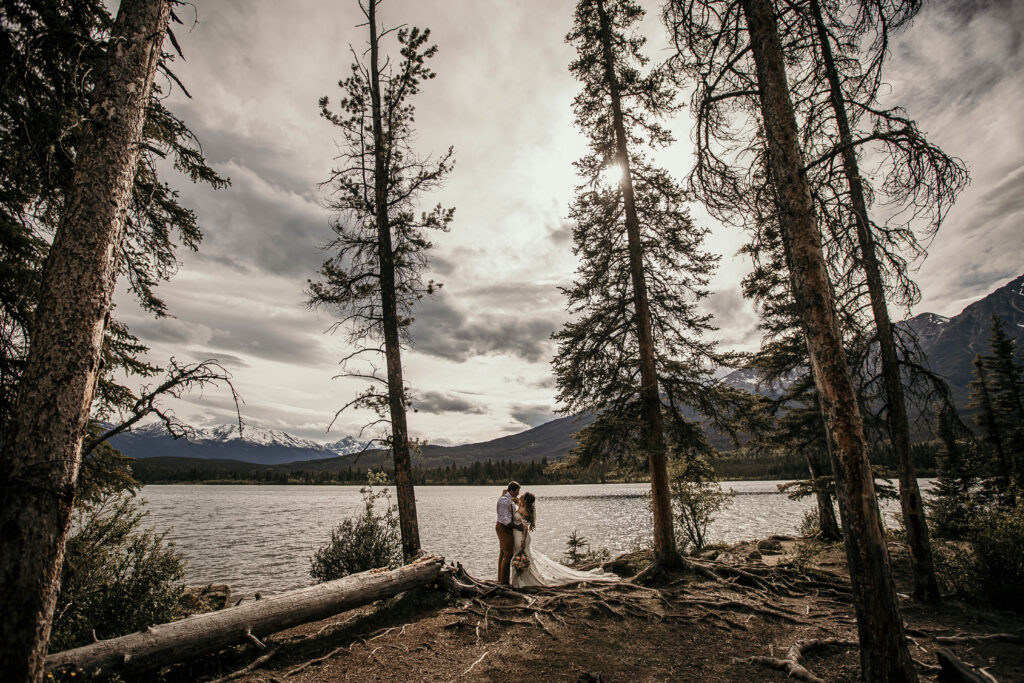 Couple eloping in the Canadian Rockies surrounded by mountains and alpine lakes, showcasing the best elopement locations in Alberta.