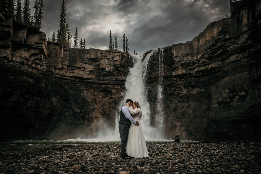 Couple hiked to a hidden waterfall during an adventure elopement in the Canadian Rockies.