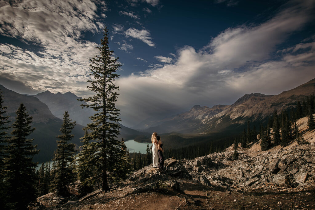 Couple eloping at Peyto Lake at sunset with wolf-shaped turquoise water below.