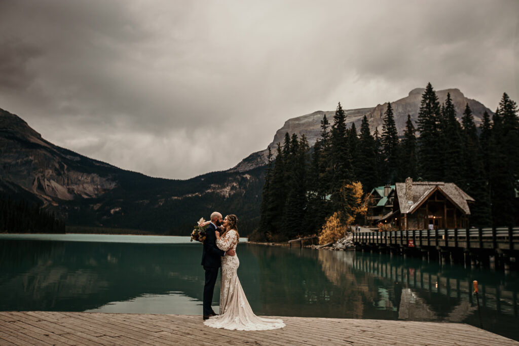 Couple eloping at Emerald Lake in Yoho National Park with forest and mountain reflections.