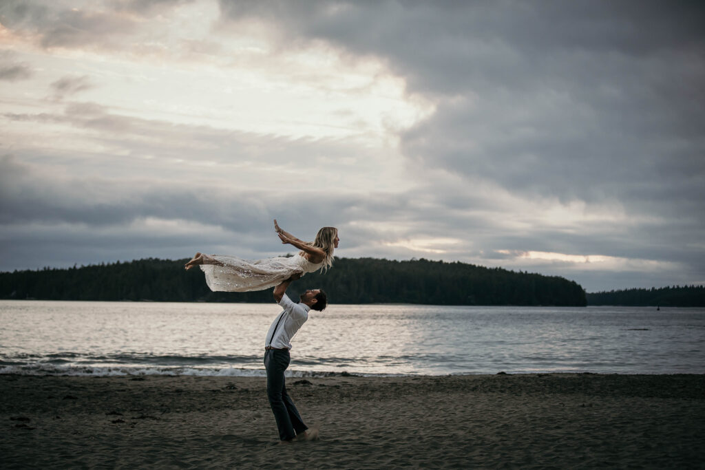 Couple exchanging vows barefoot on the beach at Tofino or Ucluelet surrounded by ocean surf.