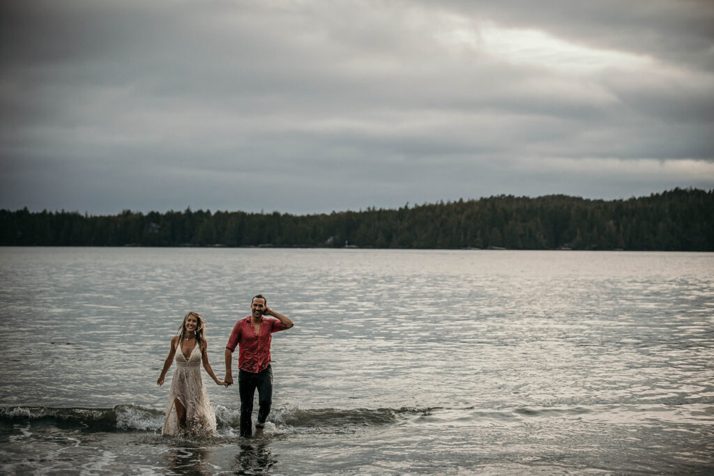 Couple playing in the shallow water during their West Coast elopement in Tofino or Ucluelet.
