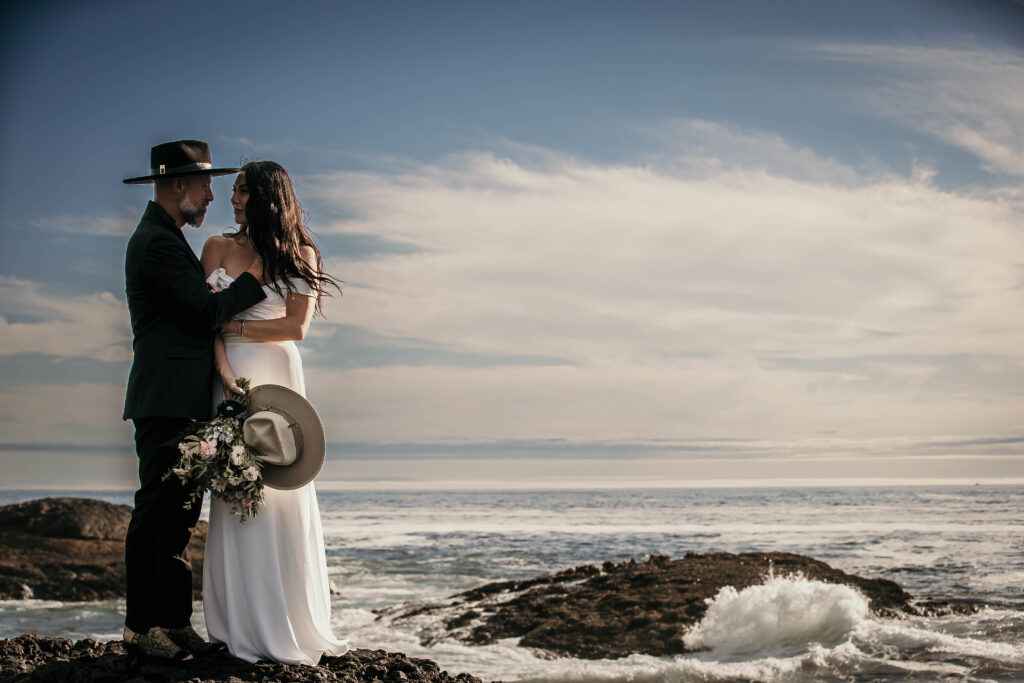 Couple celebrating their elopement at Frank’s Island in Tofino with ocean and rocky shoreline views.